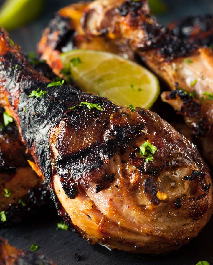 Crispy jerk chicken drum with a lemon wedge